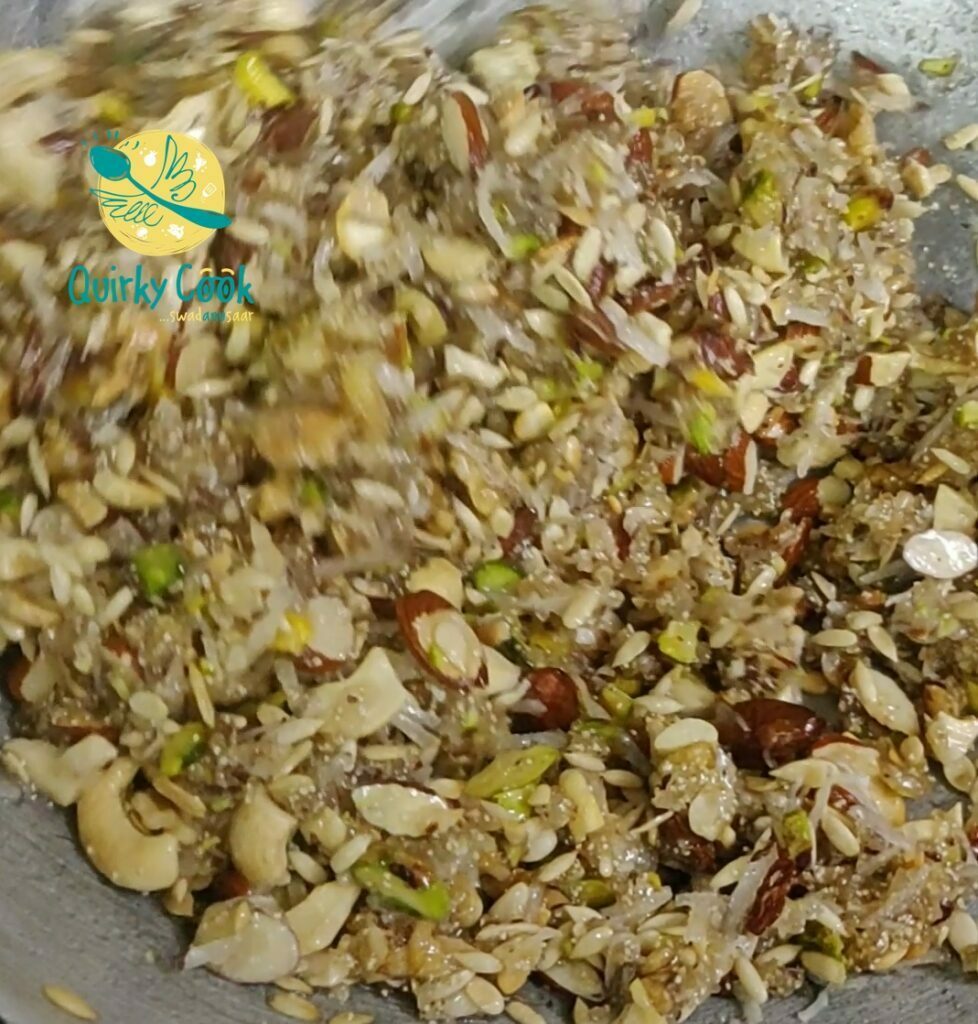 Mix all the roasted nuts and seeds into the sugar syrup to make the nuts seeds bar (mixed panjeeri)